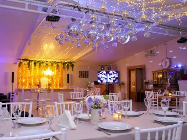 Salón cubierto montado para una fiesta nocturna con esferas espejadas y luces cálidas