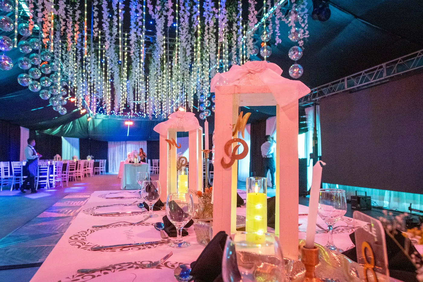 Barra temática iluminada en rosa durante una celebración nocturna en Las Cortaderas
