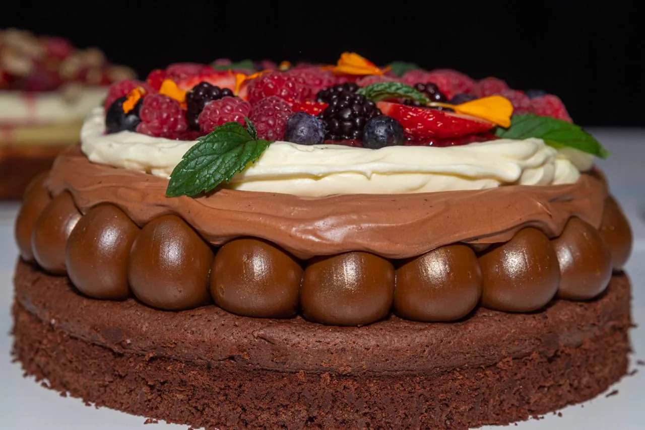 Torta de chocolate decorada con frutos rojos y crema del catering de Las Cortaderas