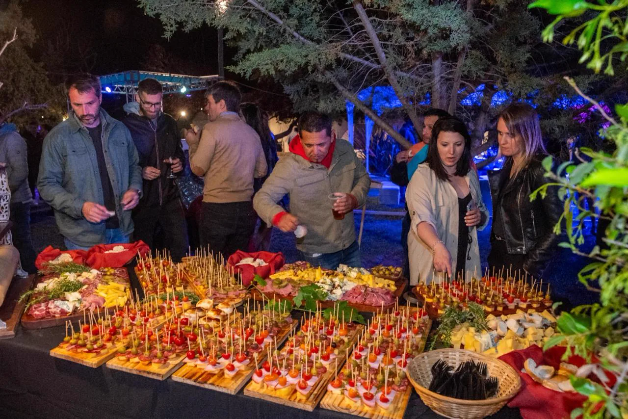 Invitados sirviéndose de una gran mesa de picada al aire libre en Las Cortaderas