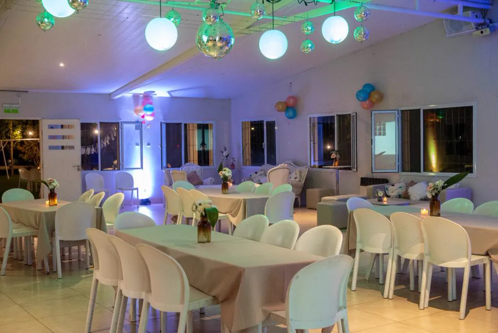 Salón cubierto ambientado con esferas espejadas y mesas blancas