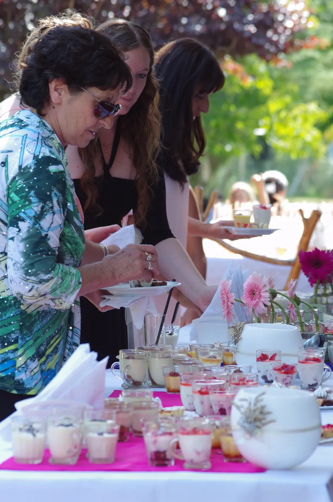 Invitadas sirviéndose de la mesa dulce en el parque