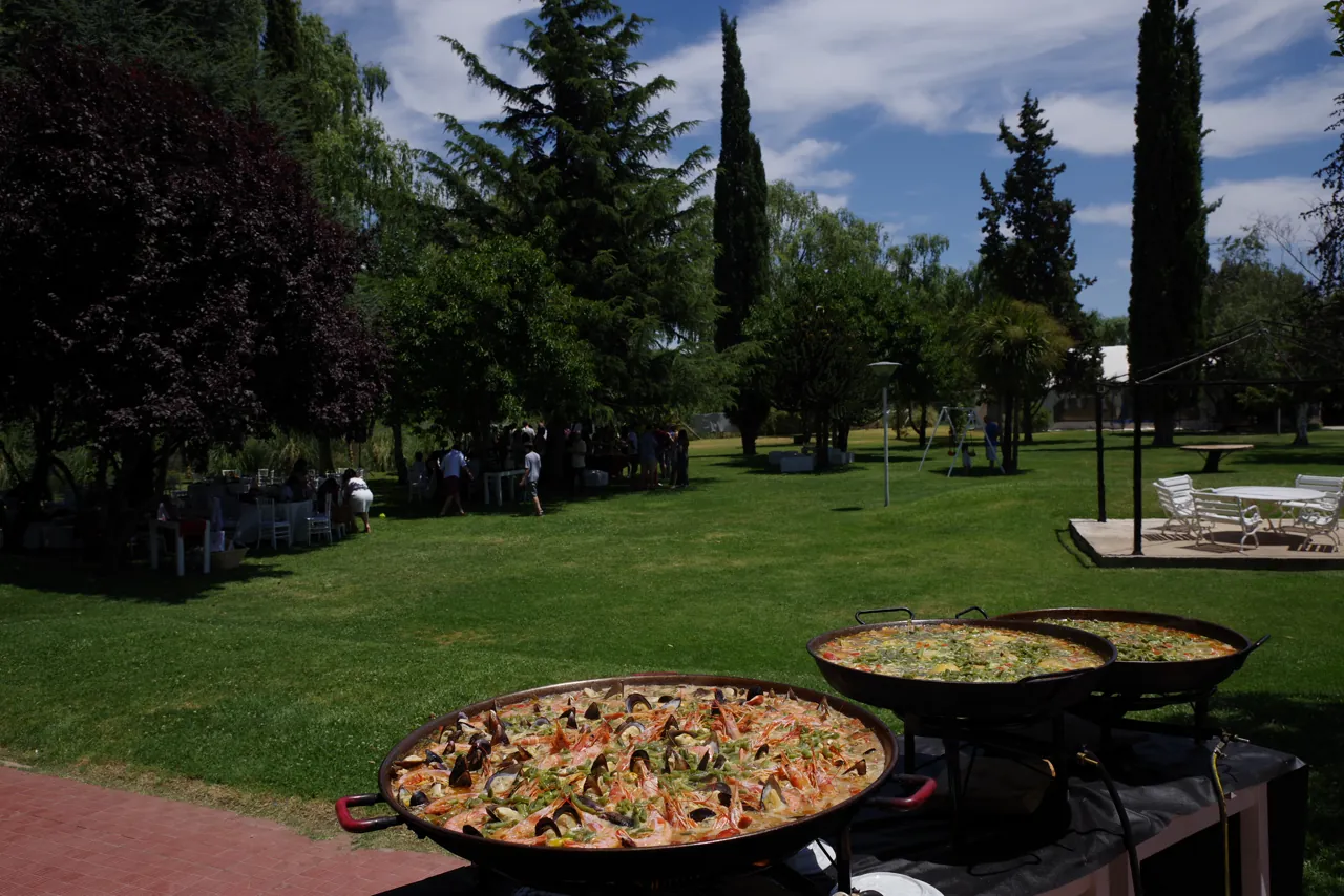 Paelleras cocinándose al fuego en el parque del predio