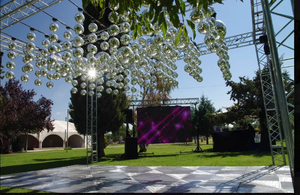 Estructura con esferas espejadas y pantalla montada en el jardín