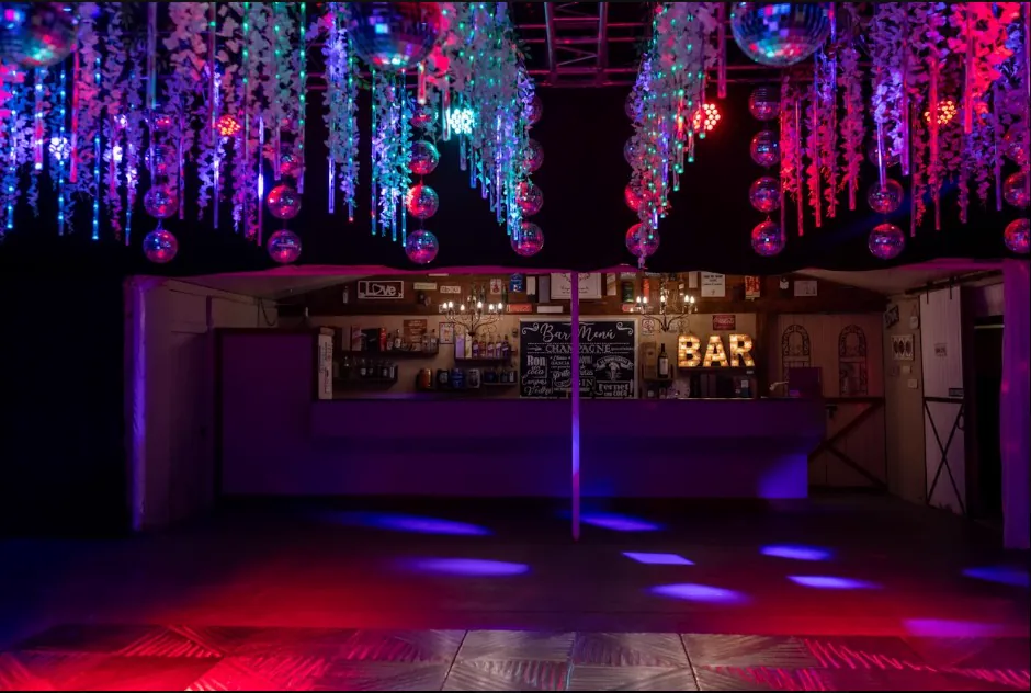 La barra del salón iluminada de noche con flores colgantes sobre la pista
