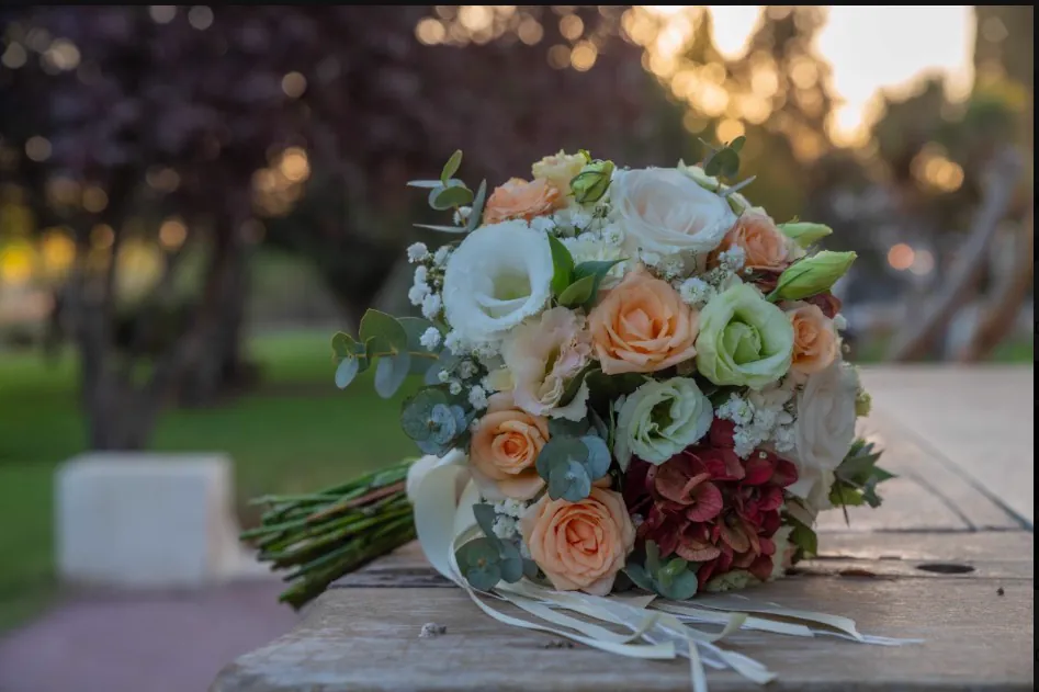 El ramo de la novia sobre una mesa del parque al atardecer