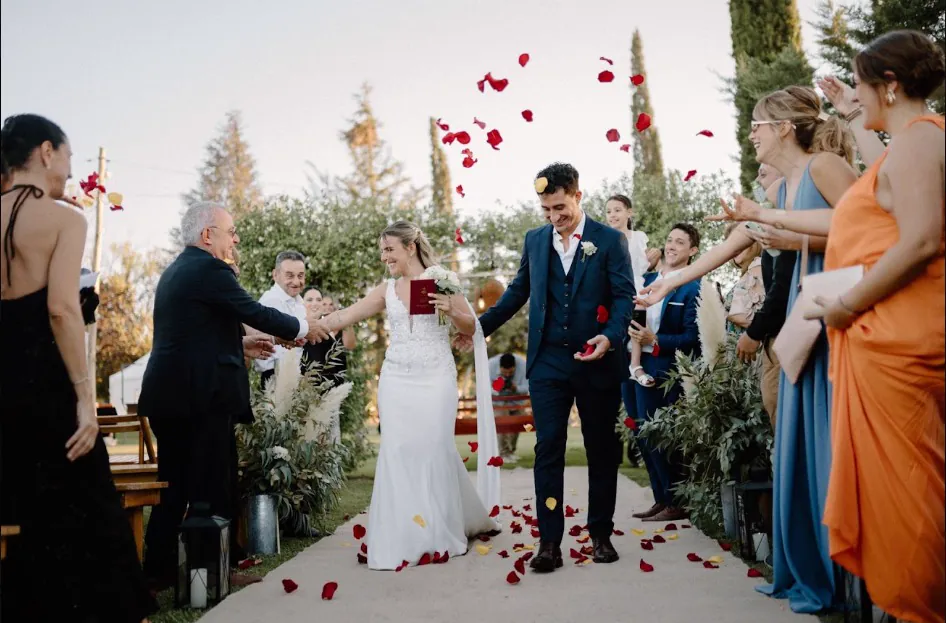 Los novios saliendo de la ceremonia bajo una lluvia de pétalos