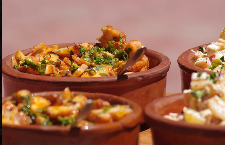 Cazuelas de barro con guiso servidas en la mesa