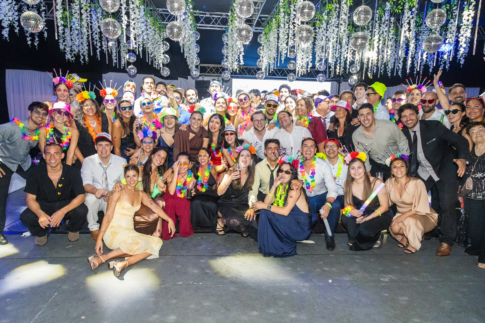 Foto grupal de invitados en una celebración nocturna en el parque